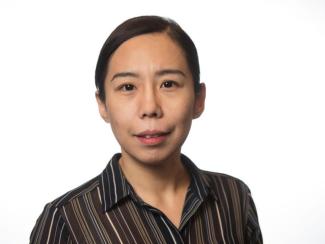 Dr. Jianqiu Zheng smiles in a headshot framed by a white background. She is wearing a brown and black vertical stripe button up