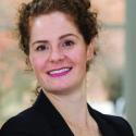 Dr. Jill McDermont smiles into the camera in a black blazer and pink shirt
